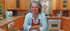 woman in apron sitting by meals she has prepared