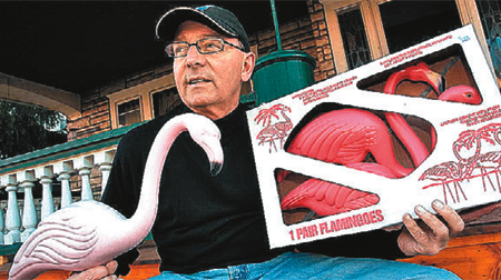 man holding pink flamingos